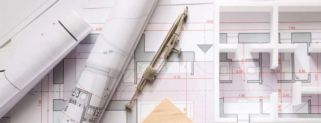 A close up of a house floor plan with a metal device on top of the floor plan.