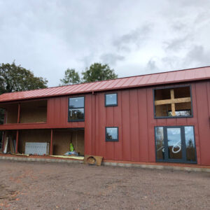 A side on view of a burnt orange building under construction with some windows missing.