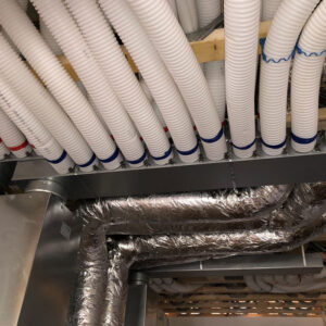 A close up of a bunch of white plastic insulation pipes and metal pipes.