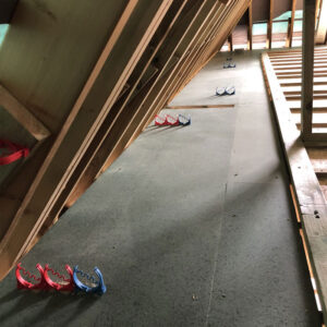 An attic floor with a ventilation system installed on it. There are also wooden beams visible.