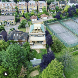 An aerial rear-view of a building under construction with a pyramidal roof.